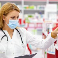 female pharmacist fulfilling a prescription holding drugs in hand, she is checking the script,Image: 566788786, License: Royalty-free, Restrictions: , Model Release: yes, Credit line: Albert Shakirov / Alamy / Alamy / Profimedia